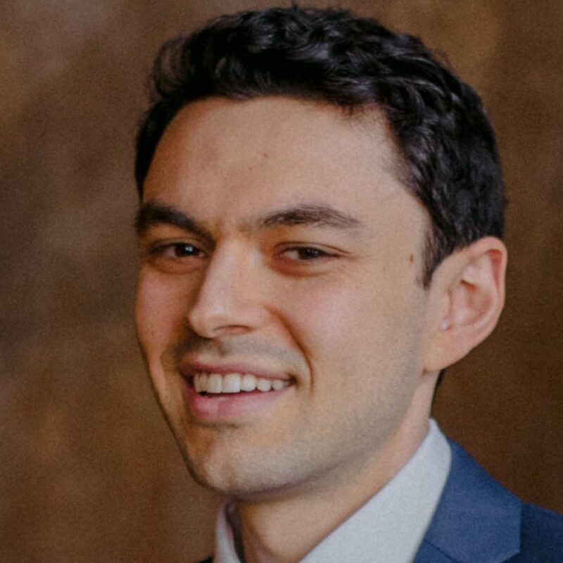 Smiling person in a suit and tie.