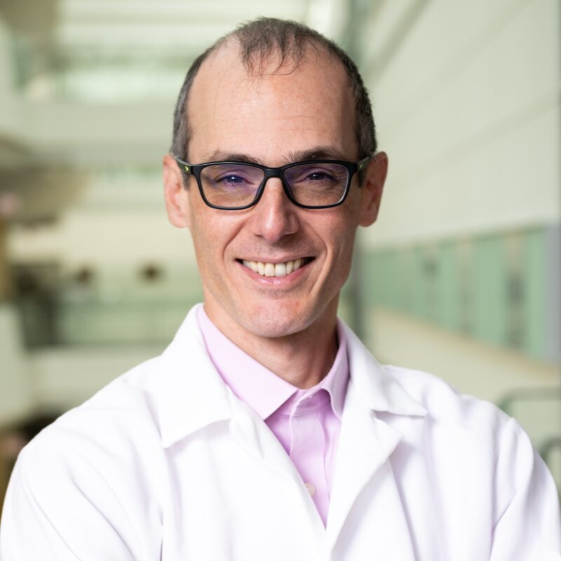 Smiling man in a lab coat.